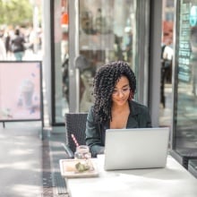 young woman on laptop while sitting outside