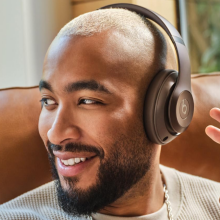 A person sitting in a chair wearing Beats Studio Pro headphones