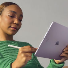 A person holding an iPad Air and Apple Pencil