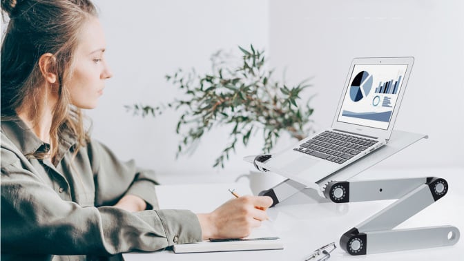 Person using laptop on a silver and black stand