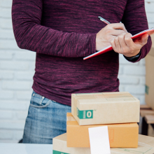 person checking list and packing boxes in warehouse