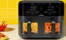 Chefman air fryer with fries and onion rings in baskets and other fried appetizers on counter beside it