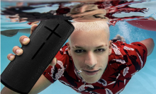 man holding a speaker under water