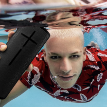 man holding a speaker under water
