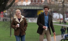 Florence Pugh and Andrew Garfield laugh in a park in "We Live in Time."