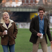 Florence Pugh and Andrew Garfield laugh in a park in "We Live in Time."