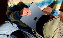 a close-up of a person putting an m3 apple macbook air into a backpack