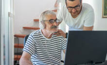 old and young man looking at a computer