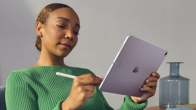 A person holding an iPad Air and Apple Pencil