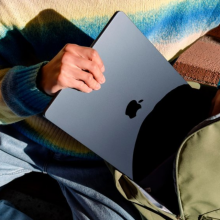 a close-up of a person putting an m3 apple macbook air into a backpack