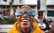 a woman using eclipse glasses to view the eclipsing sun