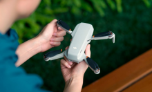 a close-up of a person holding a DJI Mini 4K drone
