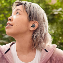 person in a red jacket wearing google pixel buds a-series