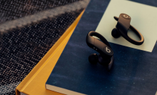 Powerbeats Pro earbuds in black laying on stack of books