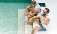 two men sitting by a pool drinking water