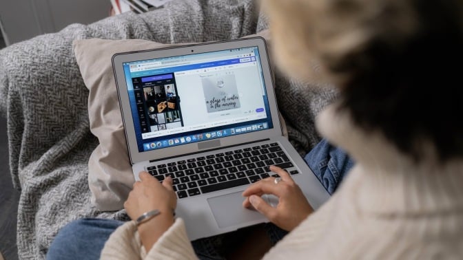 A person working on Canva on their laptop.