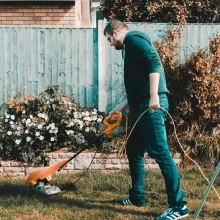 A man strimming his garden lawn