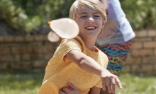 child throwing water balloon