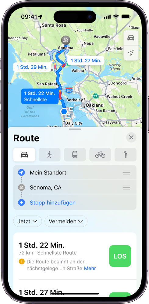 Eine Karte zeigt mehrere Fahrtrouten zwischen zwei Standorten, wobei die schnellste Route ausgewählt ist. Die Routenkarte enthält Details wie die geschätzte Wegzeit, die zurückgelegte Entfernung und eine kurze Beschreibung. Die Taste „Los“ wird rechts neben den Routendetails angezeigt.