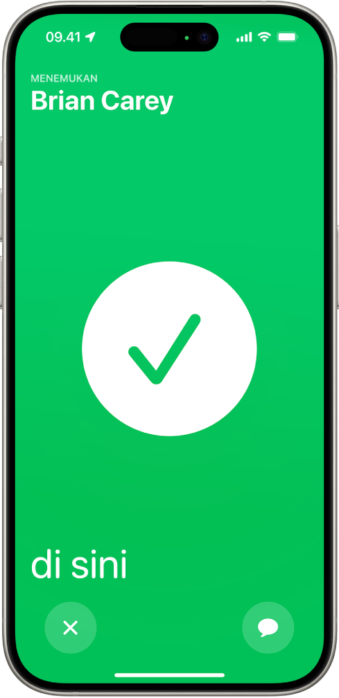 Layar iPhone berwarna hijau dengan tanda centang besar di tengahnya. Nama orang yang sedang dicari berada di pojok kiri atas, dan kata “di sini” berada di pojok kiri bawah, yang menandakan bahwa pertemuan berhasil.
