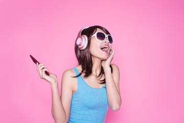 woman listening to music on phone, with wireless headphones