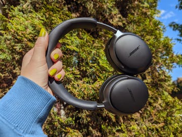 bose quietcomfort ultra headphones held up against blue sky