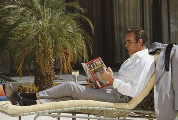 scottish actor sean connery relaxes on the set of the james bond film 'diamonds are forever', usa, may 1971 he is reading the 12th april 1971 edition of 'time' magazine, with lieutenant william calley jr on the cover photo by anwar husseingetty images