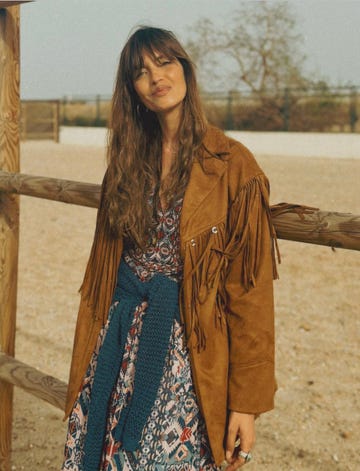 sara carbonero posando con un vestido estampado y chaqueta de flecos