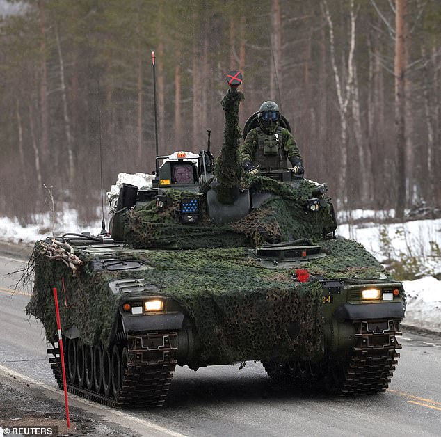 A member of the Swedish Army drives a tank as Swedish Army armoured vehicles and tanks participate in a military exercise called "Cold Response 2022"