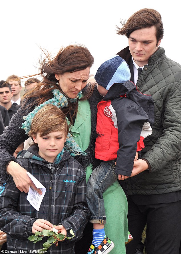 Kai (right), Nat (left) and Brock Neville (centre), of Newquay, Cornwall, lost their mother Angie, 48, just before Christmas. They are pictured mourning the loss of their father Mark in 2011