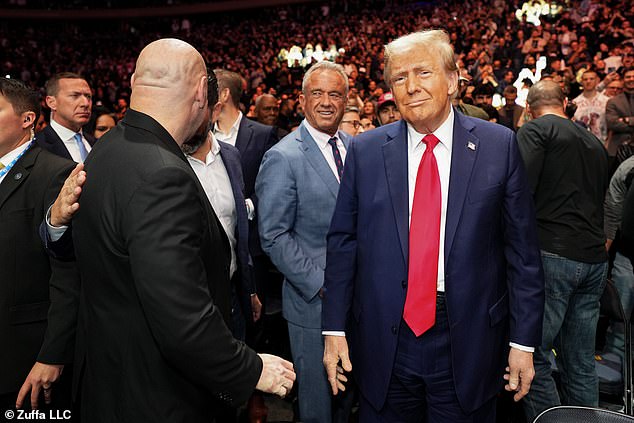 President-elect Donald Trump poses for a photo in front of Robert F. Kennedy Jr.