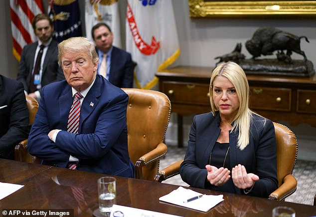 US President Donald Trump (L) watches as Florida Attorney General Pam Bondi speaks during a meeting with state and local officials on school safety in the Roosevelt Room of the White House on February 22, 2018 in Washington, DC