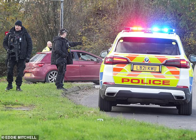 Armed police directing traffic at a roundabout close to Gatwick Airport. Roads have been closed in and out of the area