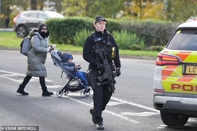 An armed police officer on the road close to Gatwick Airport. Local roads have been closed and buses cannot stop at the terminal