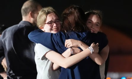 woman hugging two teenage girls