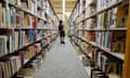 a person looks at books on shelves in a library