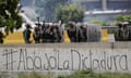 The Spanish message “Down with the dictatorship” covers a highway wall where security forces block an opposition march from reaching the National Electoral Council headquarters in Caracas, Venezuela, Wednesday, May 24, 2017. Demonstrators contend Venezuelan President Nicolas Maduro’s government is quickly becoming a full-fledged authoritarian regime, and that his call to rewrite the constitution is one more attempt to consolidate his power. They are also decrying Venezuela’s triple-digit inflation, soaring crime and vast food shortages. (AP Photo/Ariana Cubillos)