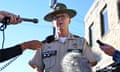 a man in speaks to people holding microphones