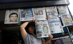 a person arranges newspapers on a stand