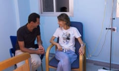 Syria’s President Bashar al-Assad sits next to his wife, Asma  in a hospital