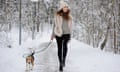 Happy woman  with beagle dog on winter walk path