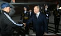 Vladimir Putin shakes a man's hand as he stands on the runway