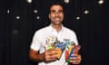 A smiling man who is Raffi Vartanian holds colorful packages of nuts and dried fruits