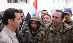 Syrian President Bashar Assad, left, talks to soldiers during his visit to the village of Maaloula, near Damascus, in April 2014