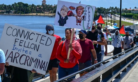 People hold Palestinian flags and signs saying: ‘Convicted fellon invites a war criminal’ and ‘Free Palestine’