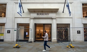 A man walks by a Burberry storefront