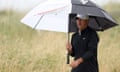 Brooks Koepka carries an umbrella.