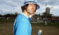 Liam Gallagher in a Kangol hat and Manchester City shirt with a can of lager in his hand.