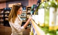 Woman looking at a shelf of wine in the supermarket.