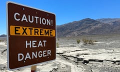 A sign warning of extreme heat with a mountain backdrop.